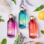 Three colorful bottles with gold caps on a white background with green leaves and flowers.