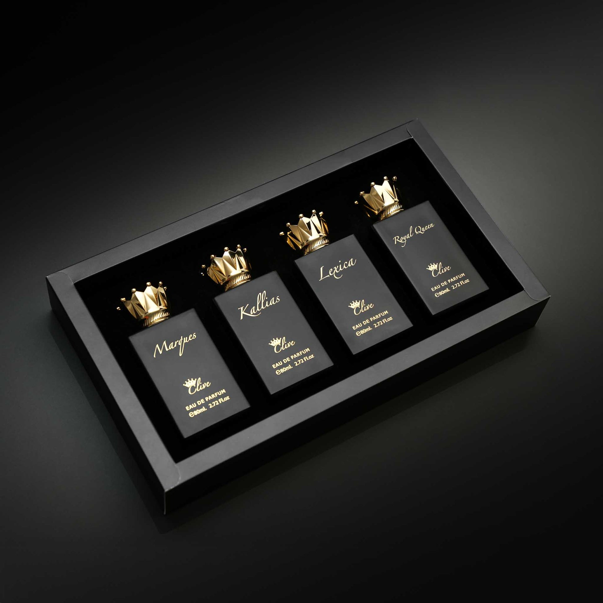 Set of perfume bottles with gold crowns in a black display case on a dark background