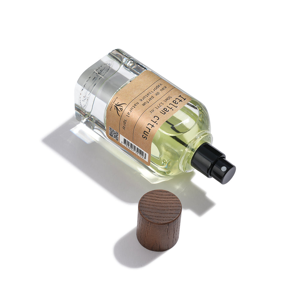Clear glass perfume bottle with wooden cap on a white background