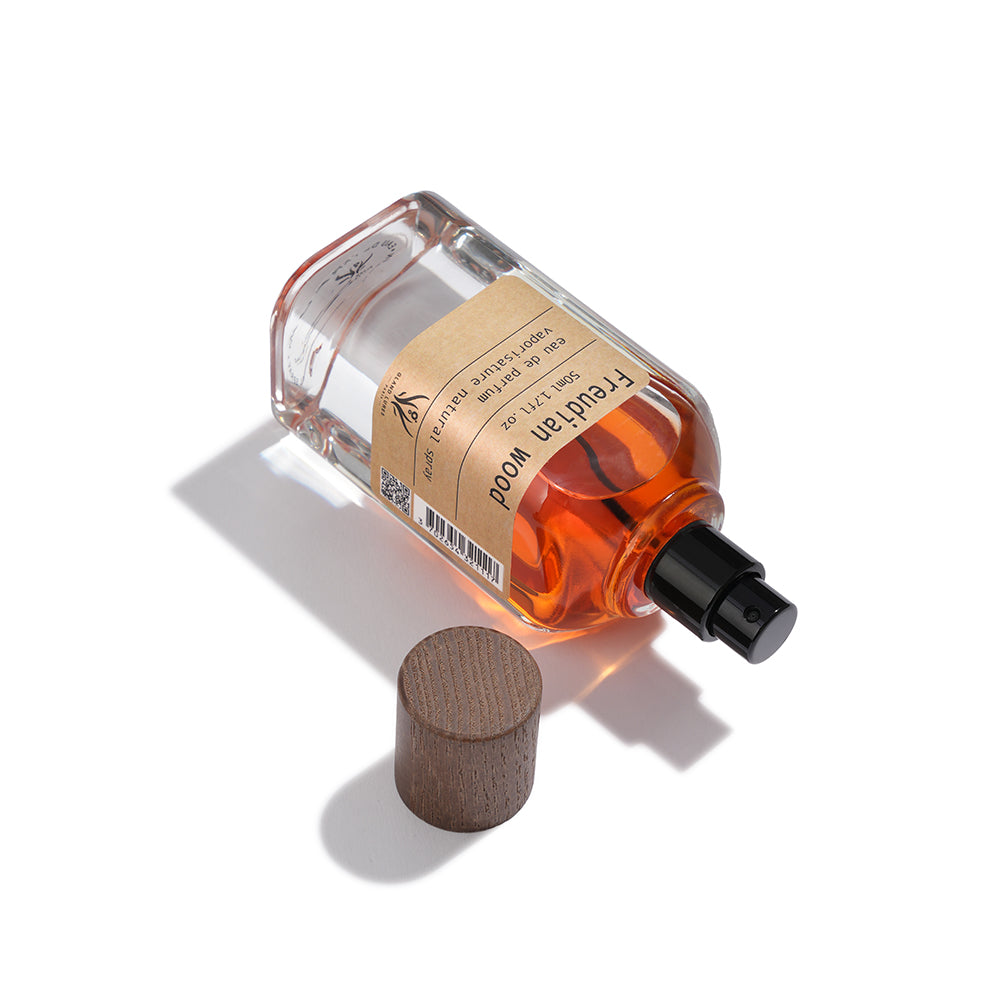 Perfume bottle with wooden cap on a white background