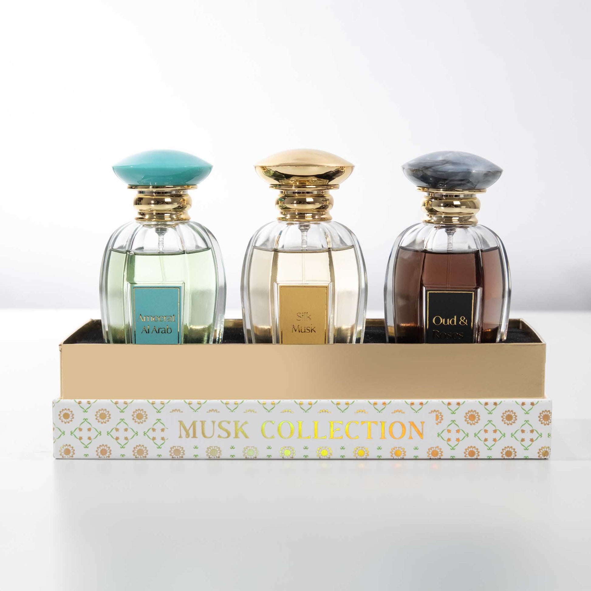 Three perfume bottles with decorative caps on a 'Musk Collection' box.