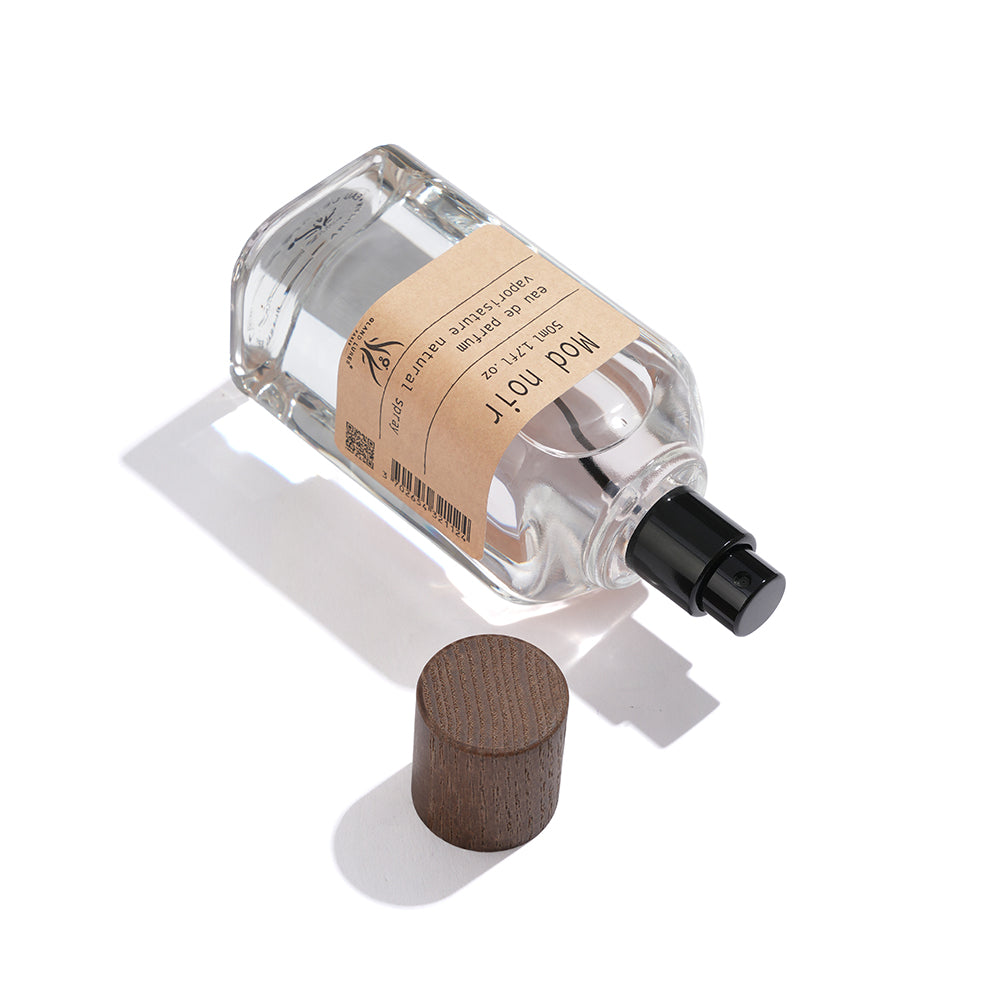 Clear perfume bottle with wooden cap on a white background