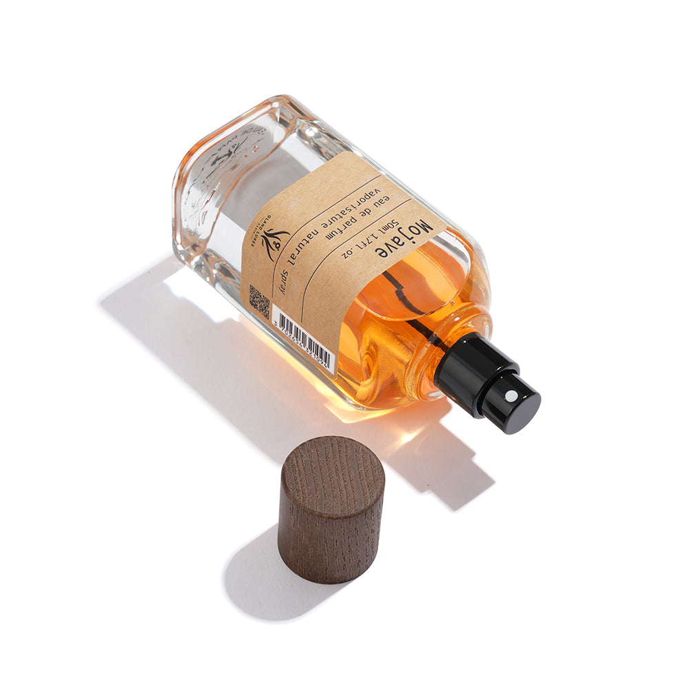 Perfume bottle with wooden cap on a white background