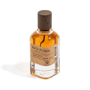 Perfume bottle labeled 'Paris Riviera' with a wooden cap on a white background