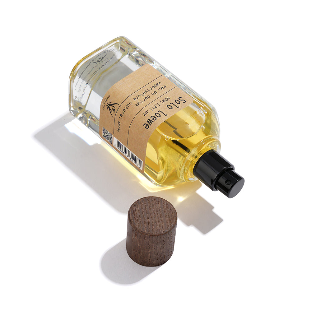 Perfume bottle with wooden cap on a white background