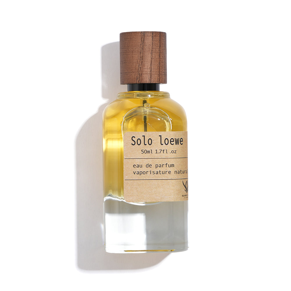 Perfume bottle with wooden cap on a white background